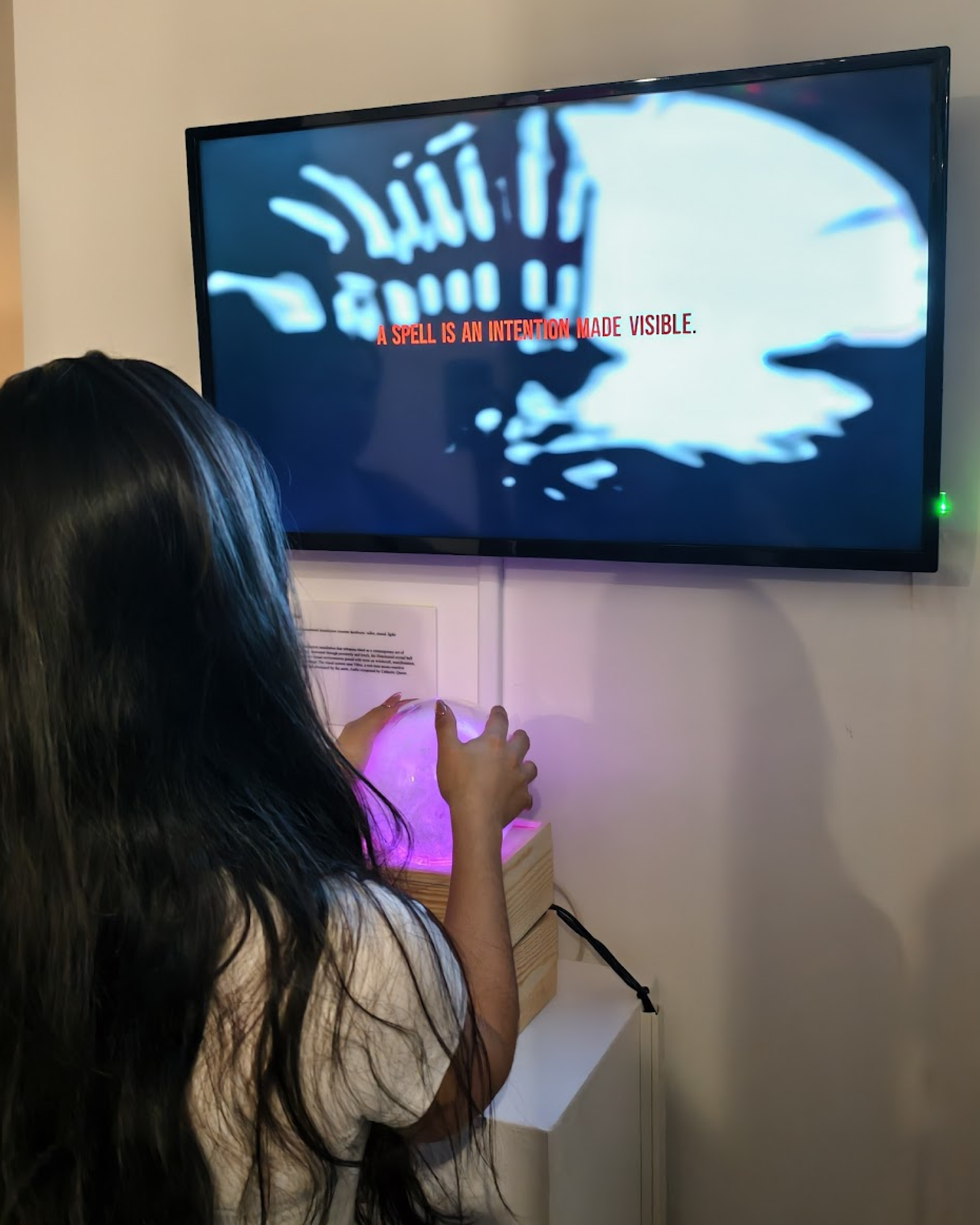 Visitor interacting with glowing crystal ball during Vibe Altar activation at Pen + Brush Gallery